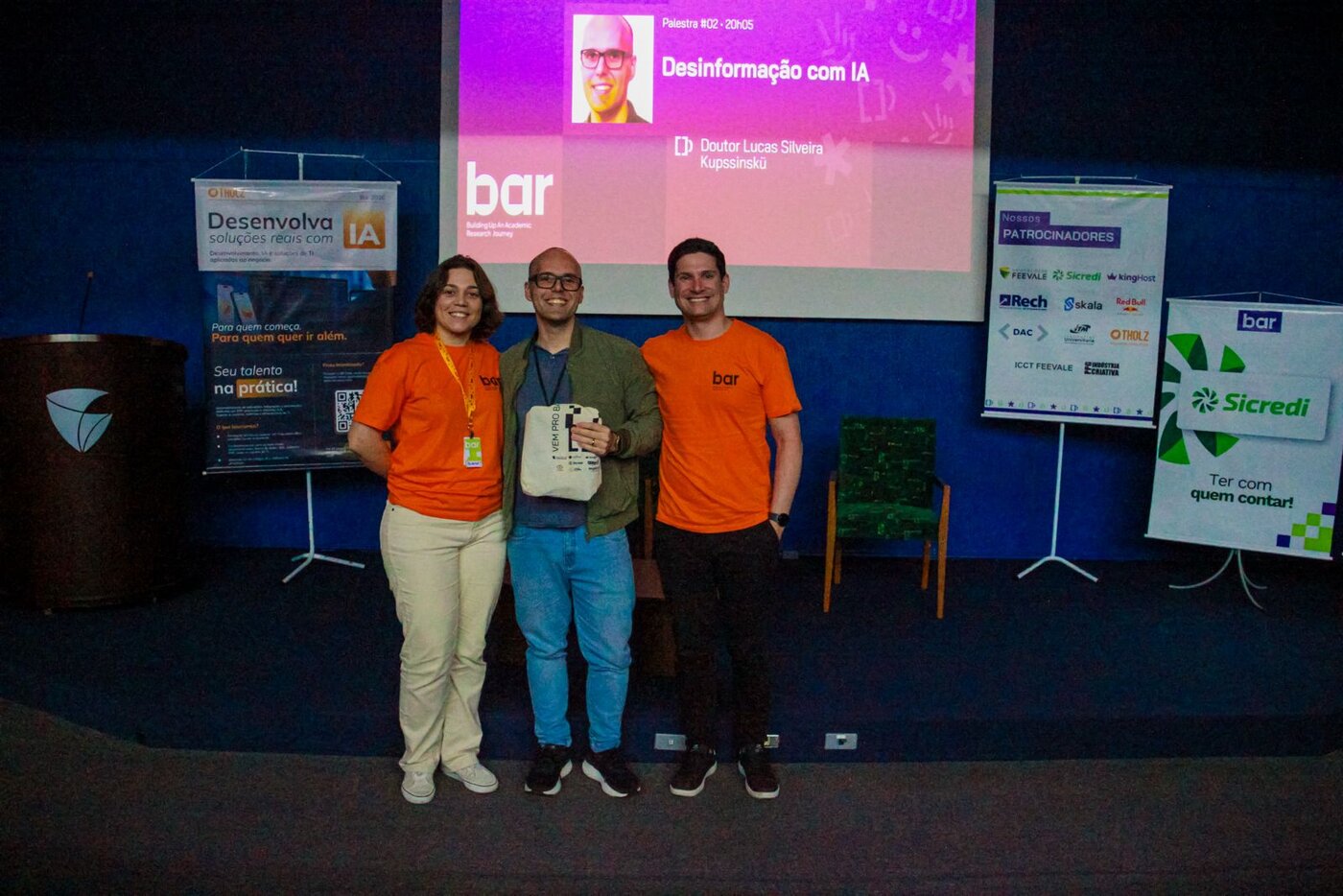 Lucas Kupssinskü with the BAR 2026 organizers in front of the talk's title slide