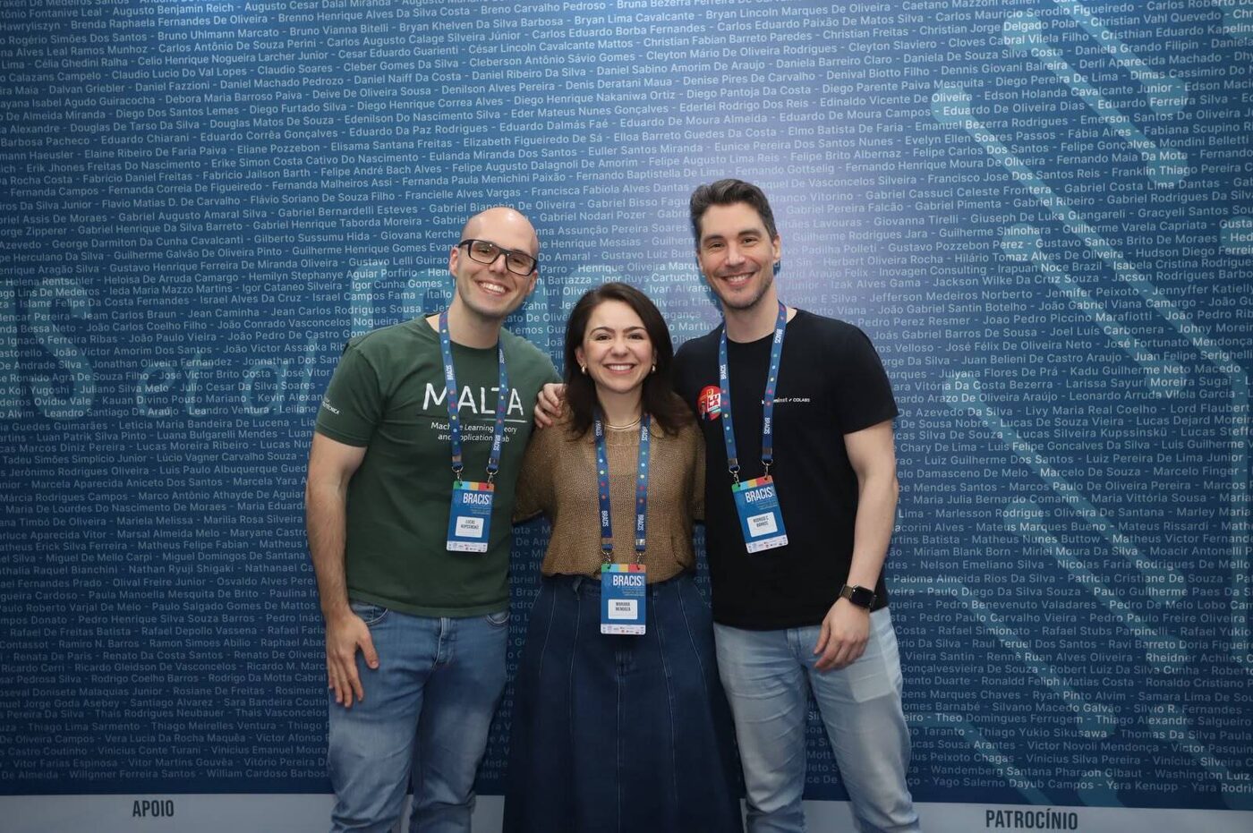 Lucas Kupssinskü with Rodrigo C. Barros and Mariana Recamonde-Mendoza in front of the BRACIS 2026 wall of participant names