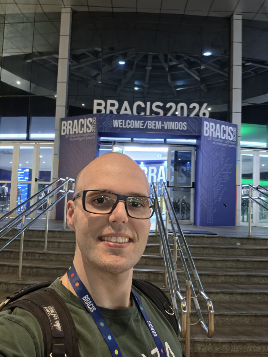 Lucas Kupssinskü at the entrance of the BRACIS 2026 venue, with the conference welcome sign behind